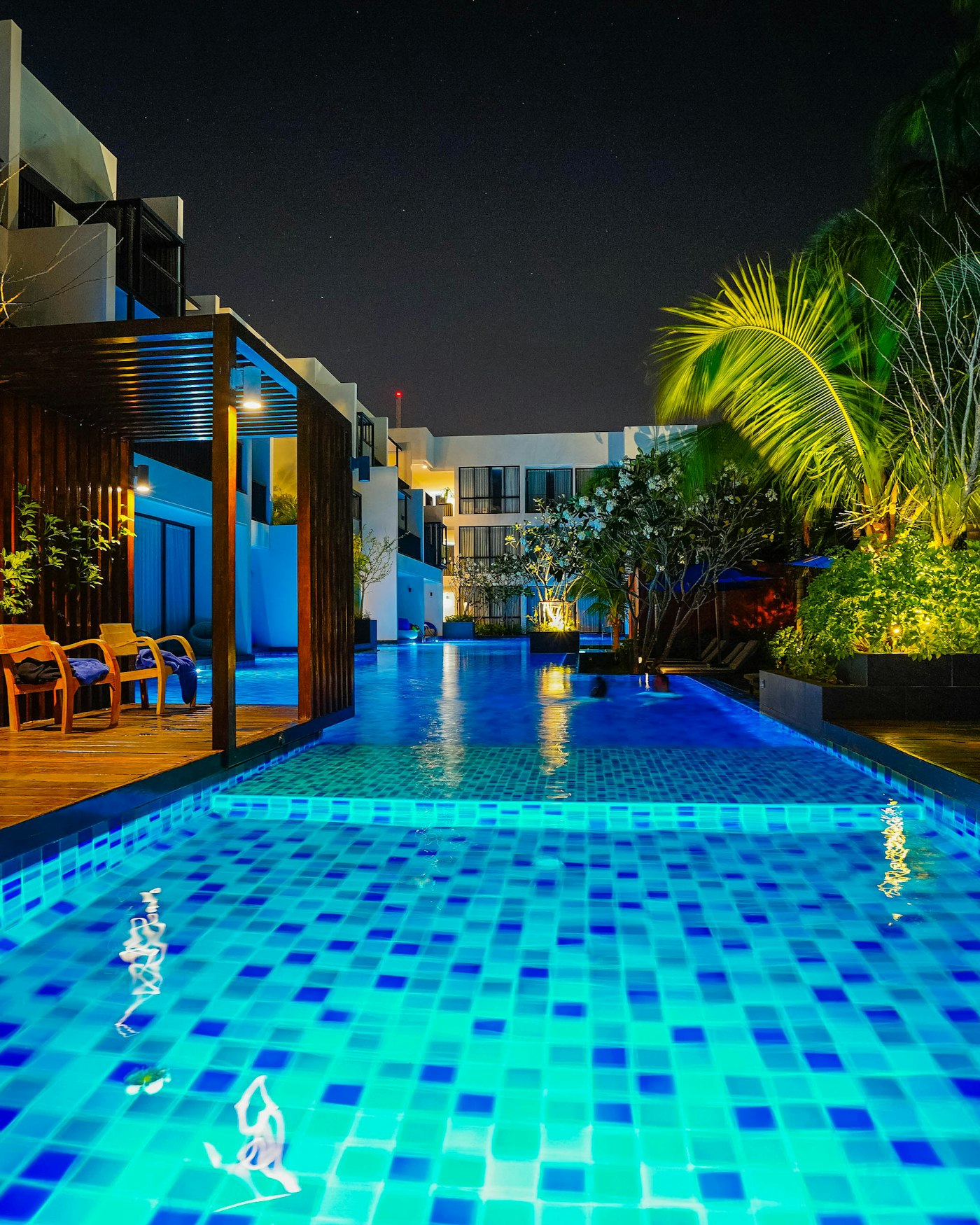 Outdoor swimming pool at a resort hotel illuminated at night